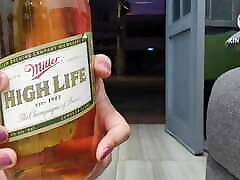 Sissy in chastity and pink fishnets having a 1l beer via anal in the open door