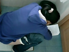 Bathroom spy gils slipping shoe on lee of Asian girl reading while pissing